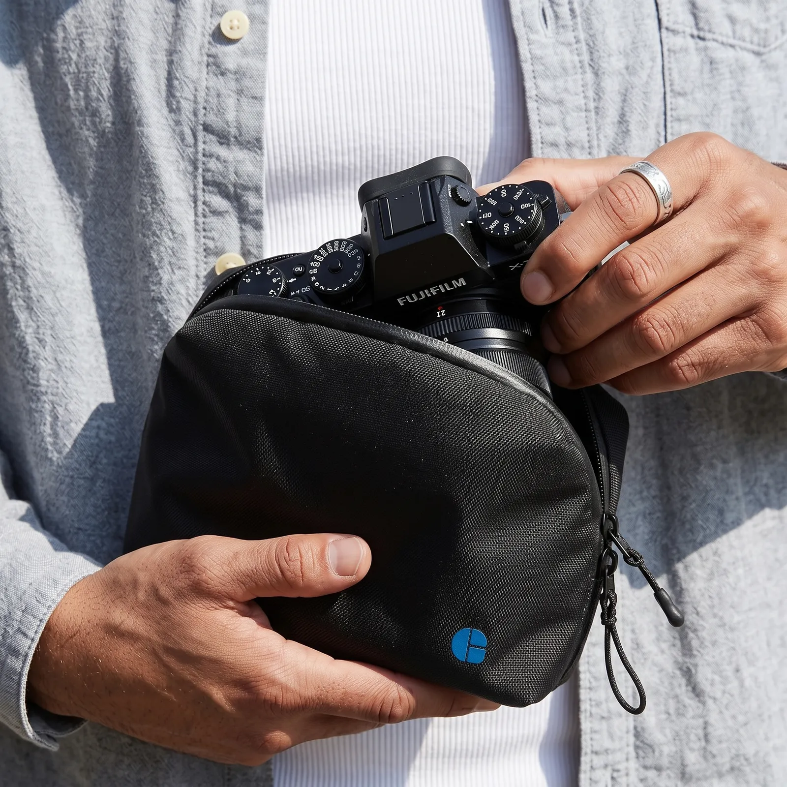 Hands sliding a camera into a branded padded case